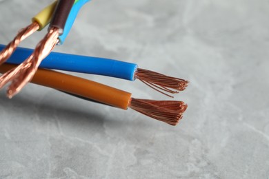 Photo of Colorful electrical wires on gray textured surface, closeup