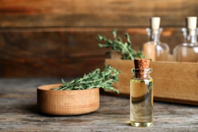 Composition with essential oil in glass bottle on wooden table