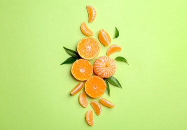 Composition with tangerines and leaves on color background, flat lay