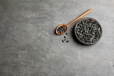 Photo of Bowl and spoon with sunflower seeds on table, top view