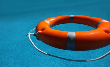 Bright orange inflatable ring floating in swimming pool