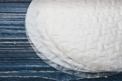 Dry rice paper on blue wooden table, closeup