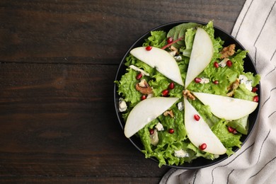 Photo of Delicious pear salad in bowl on wooden table, top view. Space for text