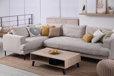 Photo of Stylish living room interior with comfortable grey sofa and coffee table