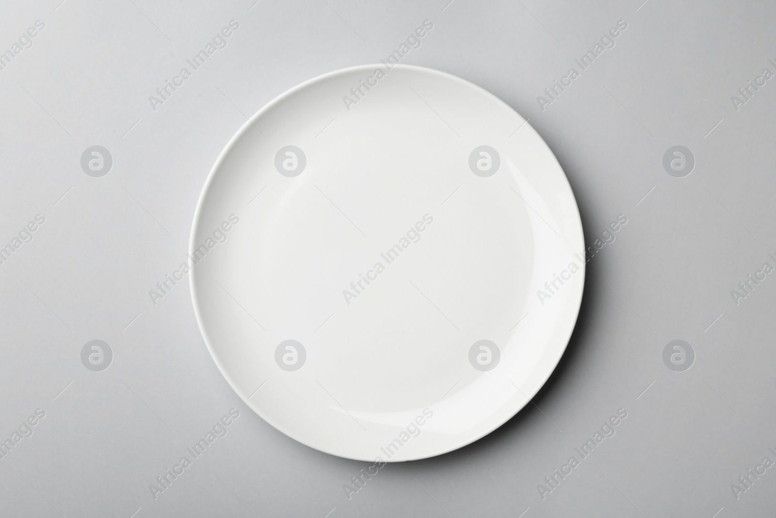 Photo of Clean empty plate on grey background, top view