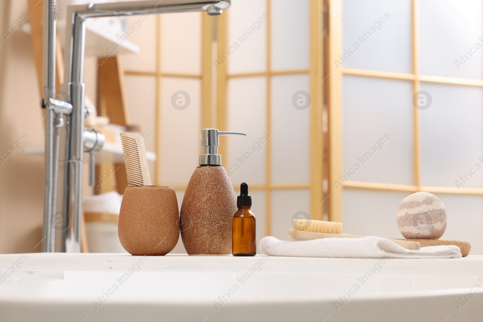 Photo of Different personal care products and accessories on bath tub in bathroom