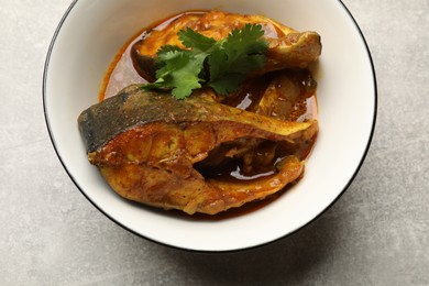 Photo of Tasty fish curry on light grey table, closeup. Indian cuisine