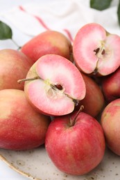 Tasty apples with red pulp on table, closeup