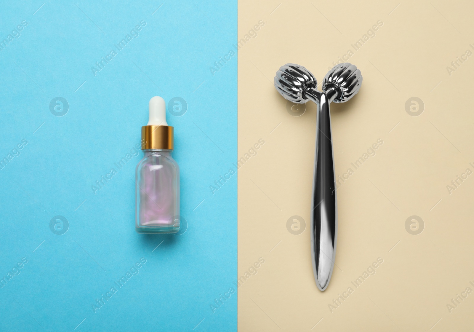 Photo of Metal face roller and cosmetic product on color background, flat lay