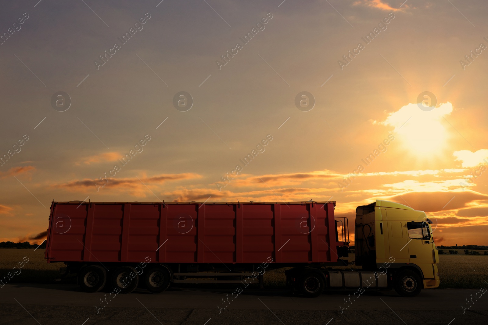 Image of Truck parked on country road at sunset