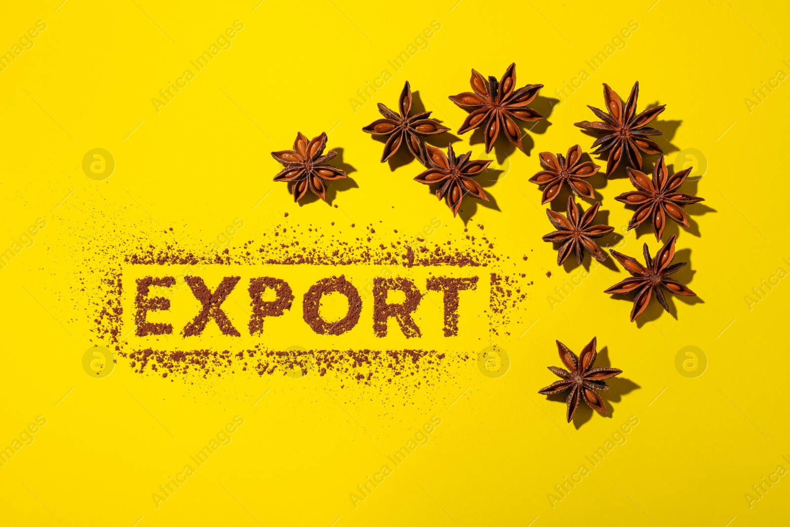 Photo of Word Export made of cacao powder and anise stars on yellow background, flat lay