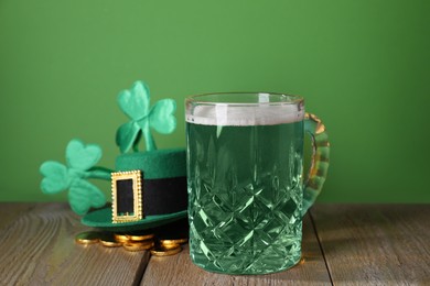 Photo of St. Patrick's day party. Green beer, leprechaun hat, gold and decorative clover leaves on wooden table