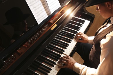 Photo of Man playing piano indoors, above view. Talented musician