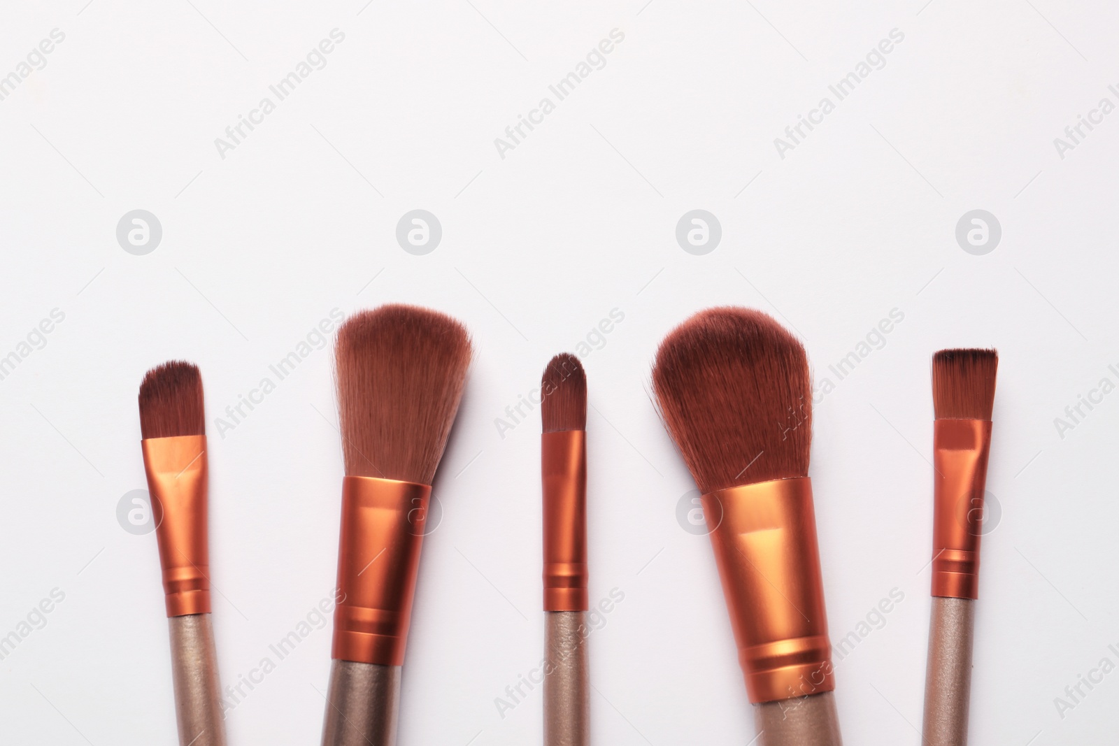 Photo of Set of makeup brushes on white background, flat lay. Space for text