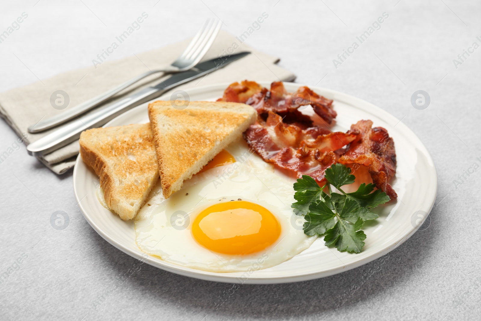 Photo of Delicious breakfast with sunny side up egg served on light table