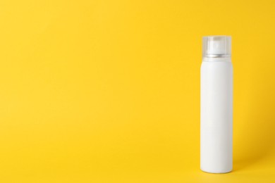Bottle of dry shampoo on yellow background, space for text