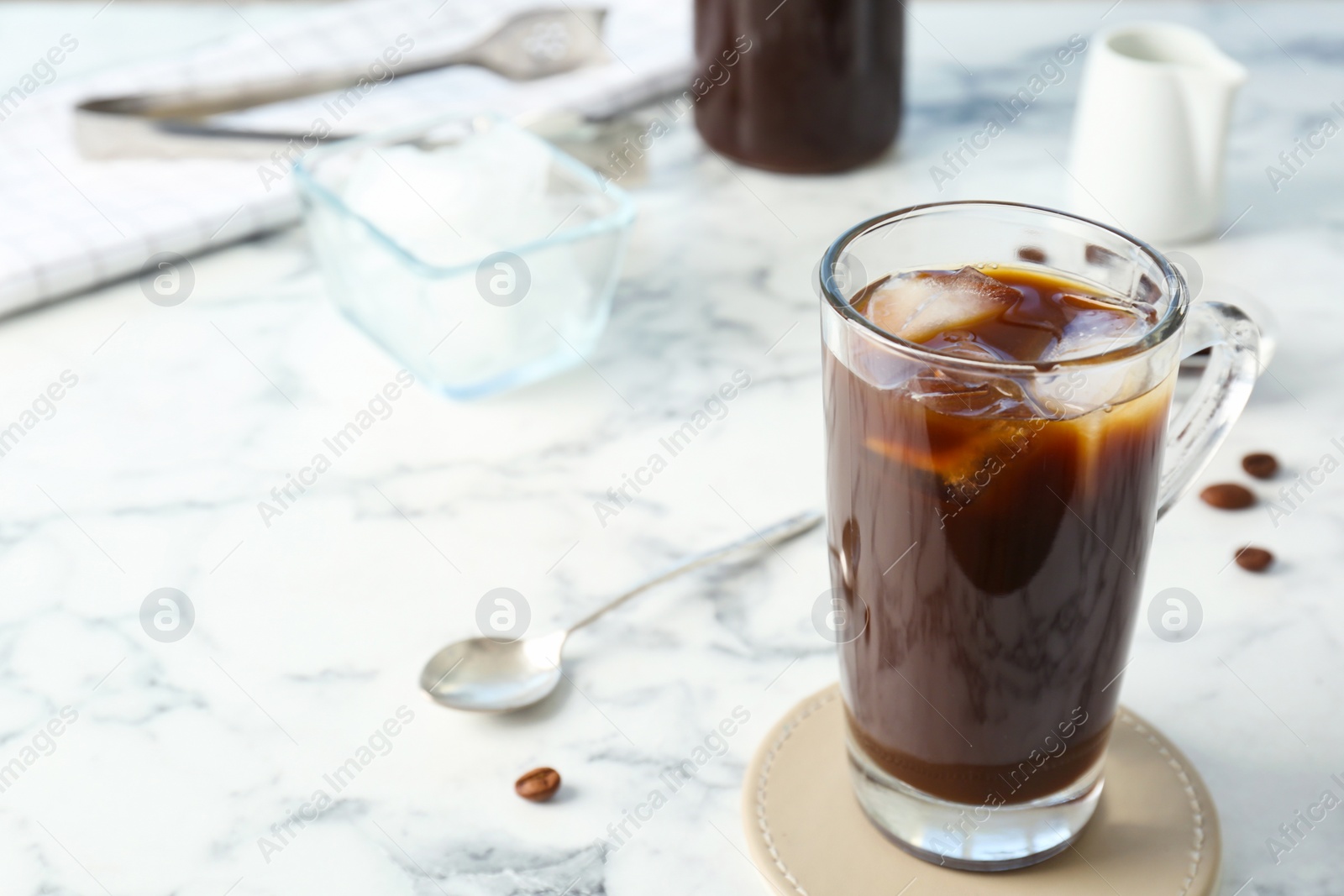 Photo of Glass cup with cold brew coffee on light background