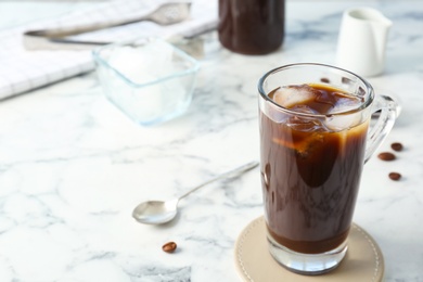 Photo of Glass cup with cold brew coffee on light background