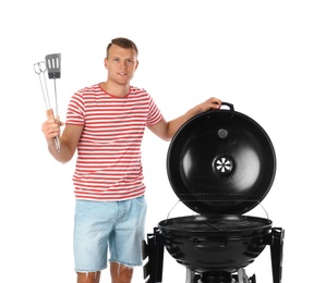 Man with barbecue grill and utensils on white background