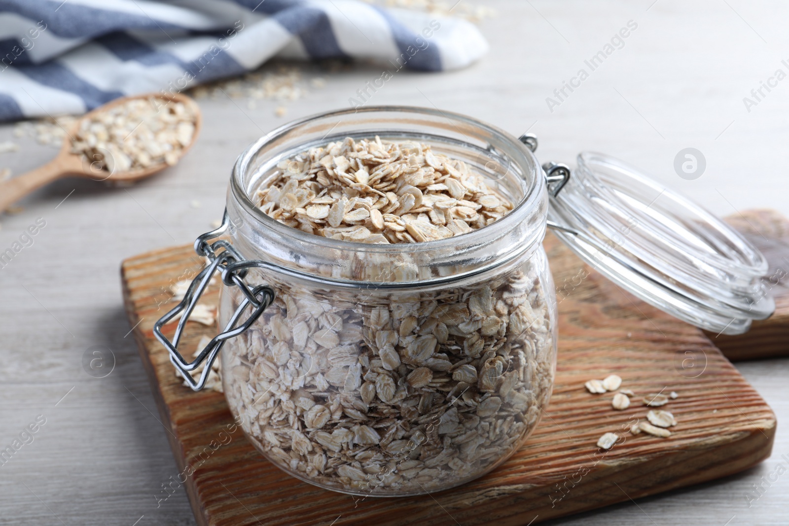 Photo of Glass jar with oatmeal on white wooden table