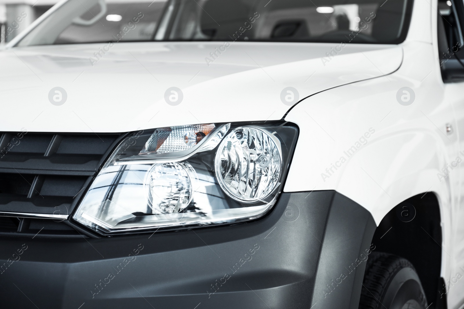 Photo of New luxury car in modern auto dealership, closeup