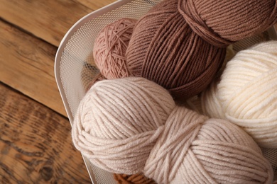 Photo of Woolen yarns on wooden table, top view