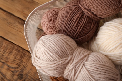 Woolen yarns on wooden table, top view