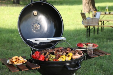Photo of Tasty meat and vegetables on barbecue grill outdoors