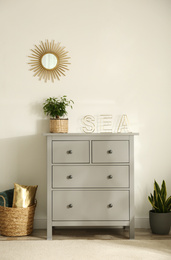 Grey chest of drawers in stylish room interior