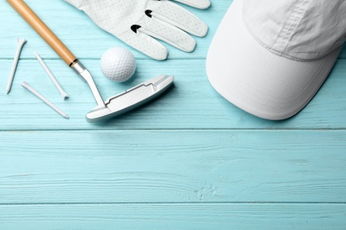 Flat lay composition with golf accessories and space for text on blue wooden background