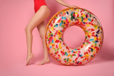 Photo of Young woman with inflatable ring against pink background, closeup