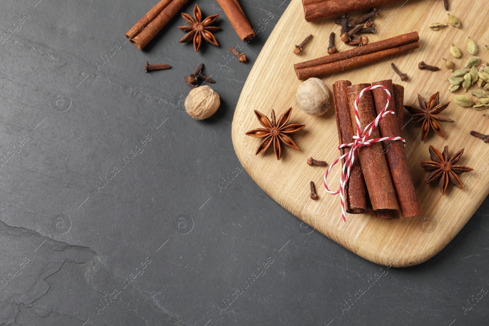 Photo of Different spices and nuts on gray table, flat lay. Space for text