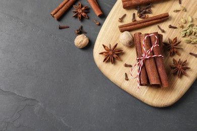 Different spices and nuts on gray table, flat lay. Space for text