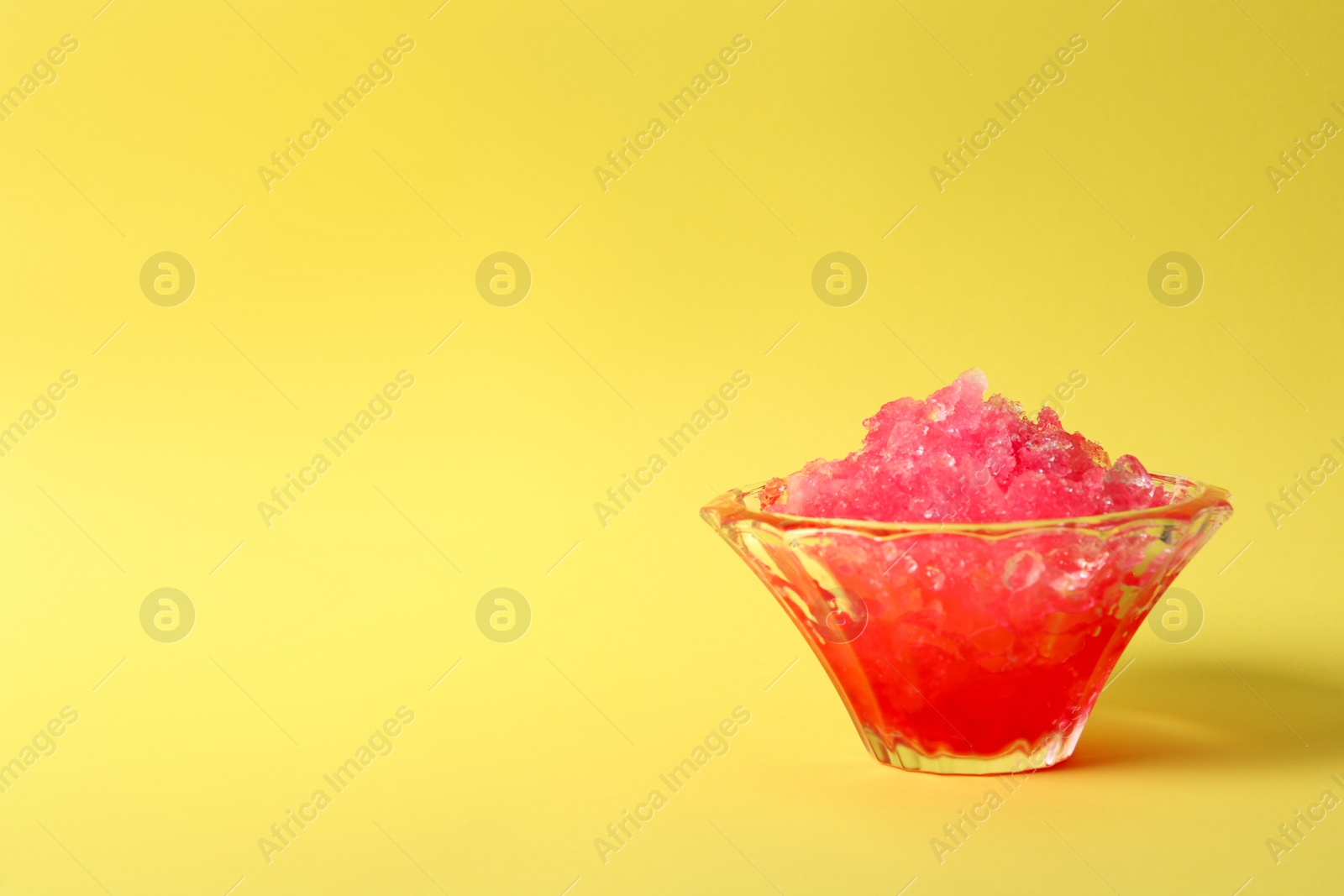 Photo of Shaving ice in glass dessert bowl on yellow  background, space for text