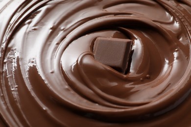 Tasty milk chocolate paste and piece as background, closeup