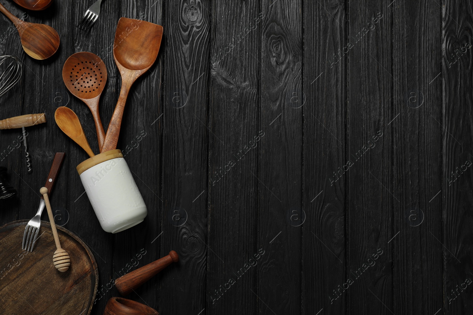 Photo of Set of different kitchen utensils on black wooden table, flat lay. Space for text