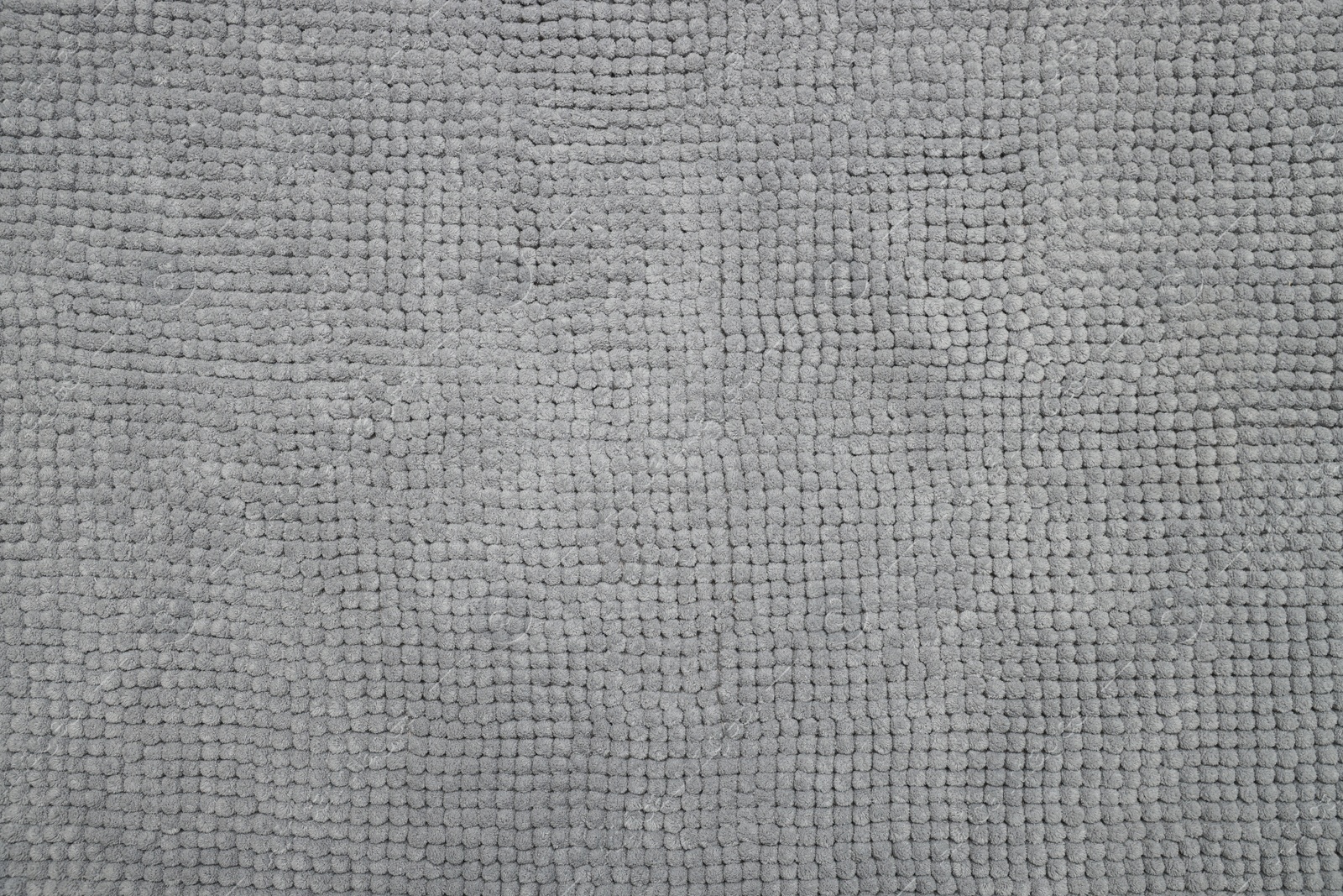 Photo of Soft grey bath mat as background, top view