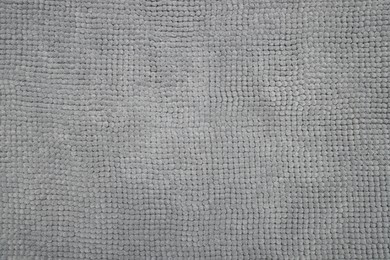 Soft grey bath mat as background, top view