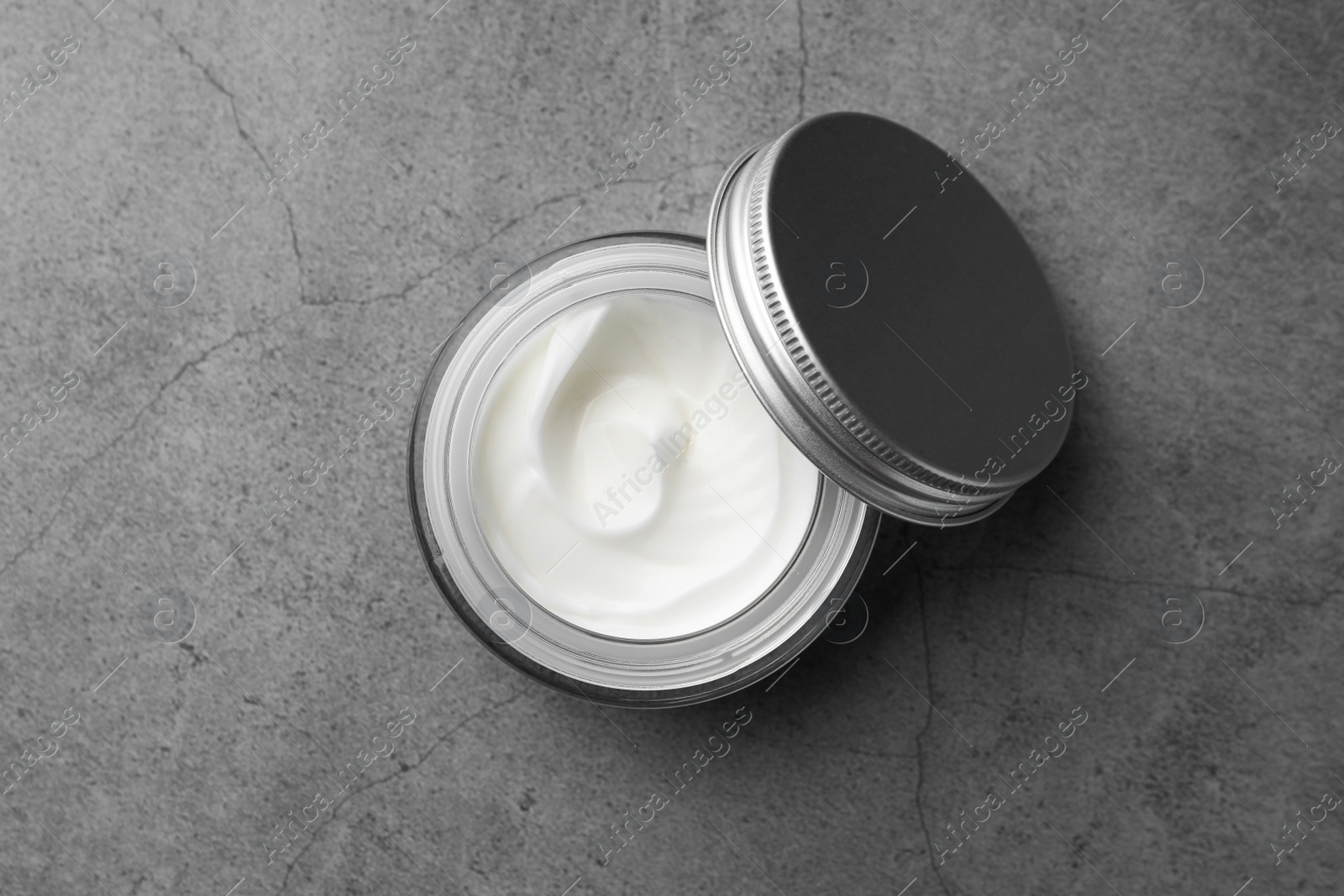 Photo of Jar of face cream on grey table, top view