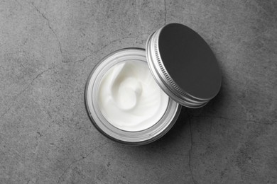 Photo of Jar of face cream on grey table, top view