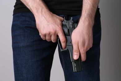 Photo of Man reloading gun on grey background, closeup
