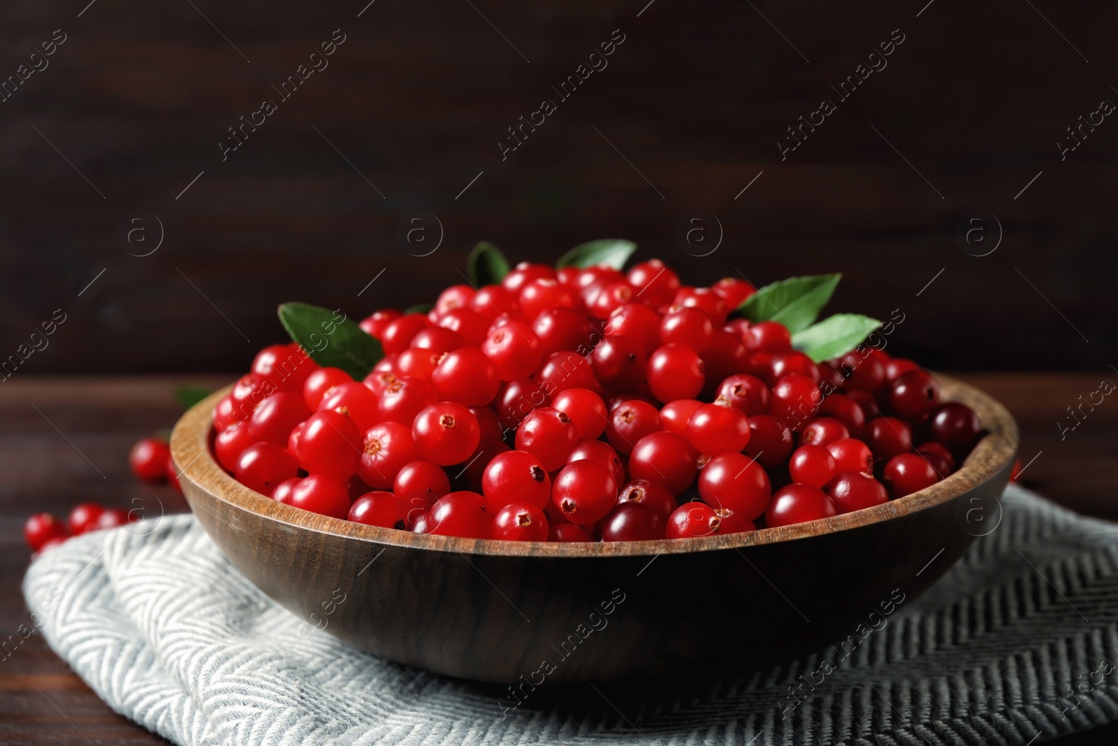 Photo of Plate with tasty ripe cranberries on table, closeup