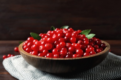 Plate with tasty ripe cranberries on table, closeup