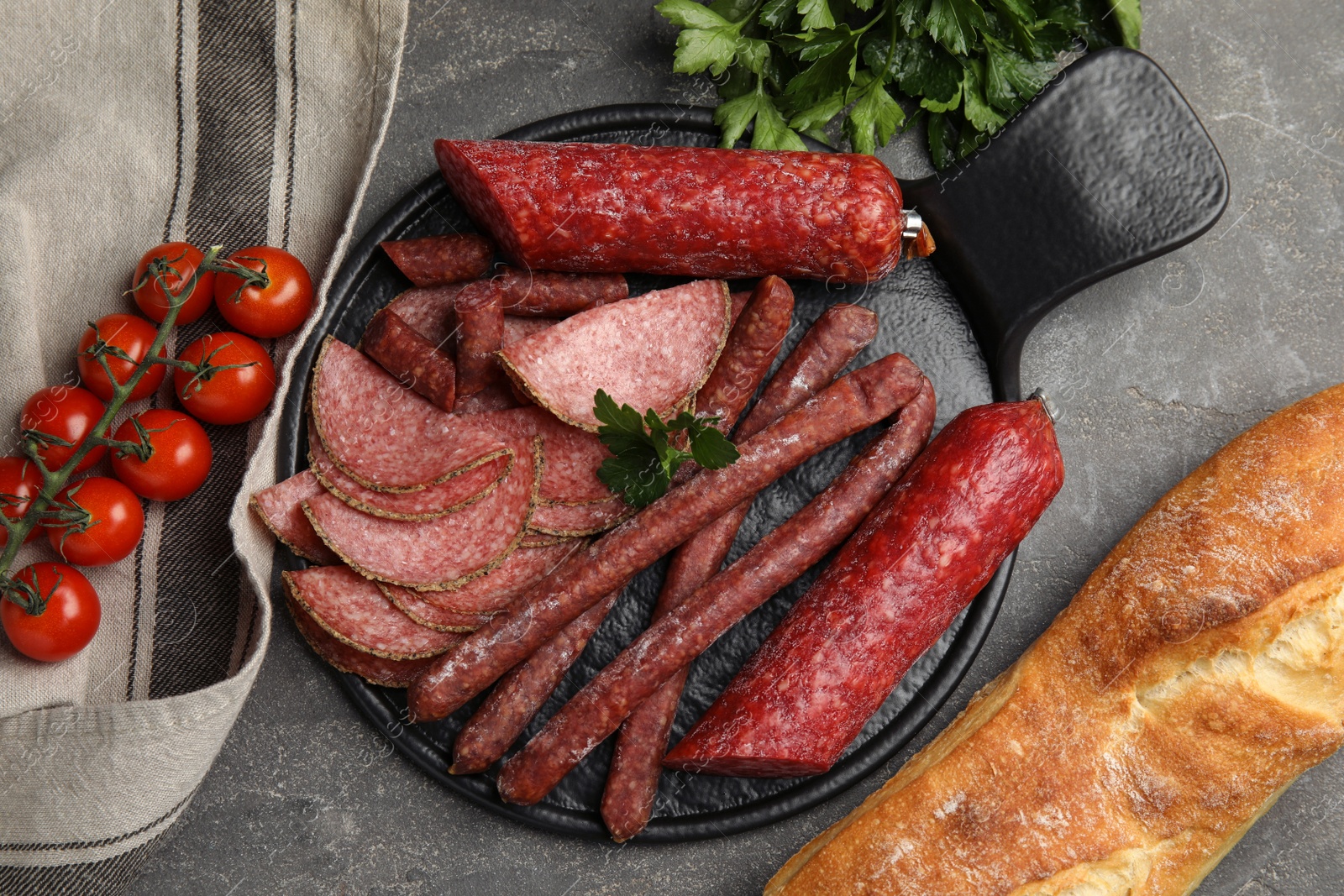 Photo of Different tasty sausages on grey table, flat lay