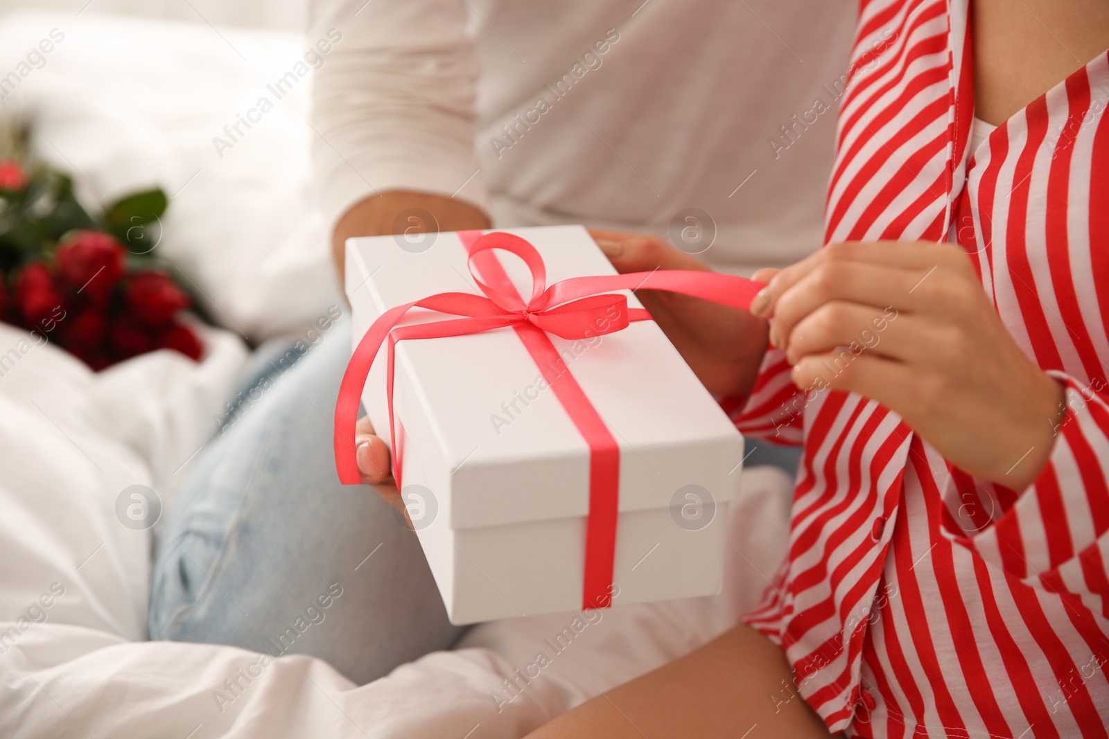 Photo of Lovely couple with gift box at home, closeup. Valentine's day celebration