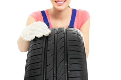 Photo of Female mechanic with car tire on white background, closeup