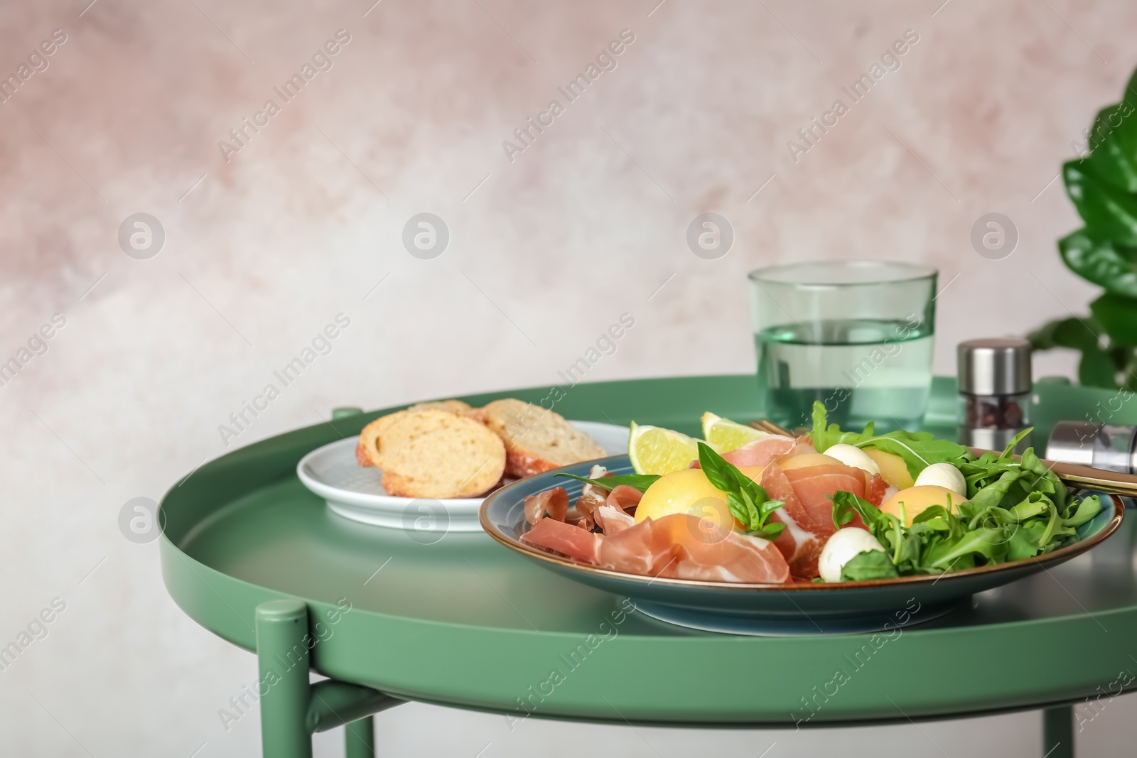 Photo of Plate with melon balls, mozzarella and prosciutto on table. Space for text