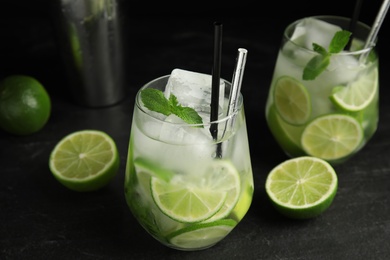 Photo of Delicious mojito and ingredients on black table