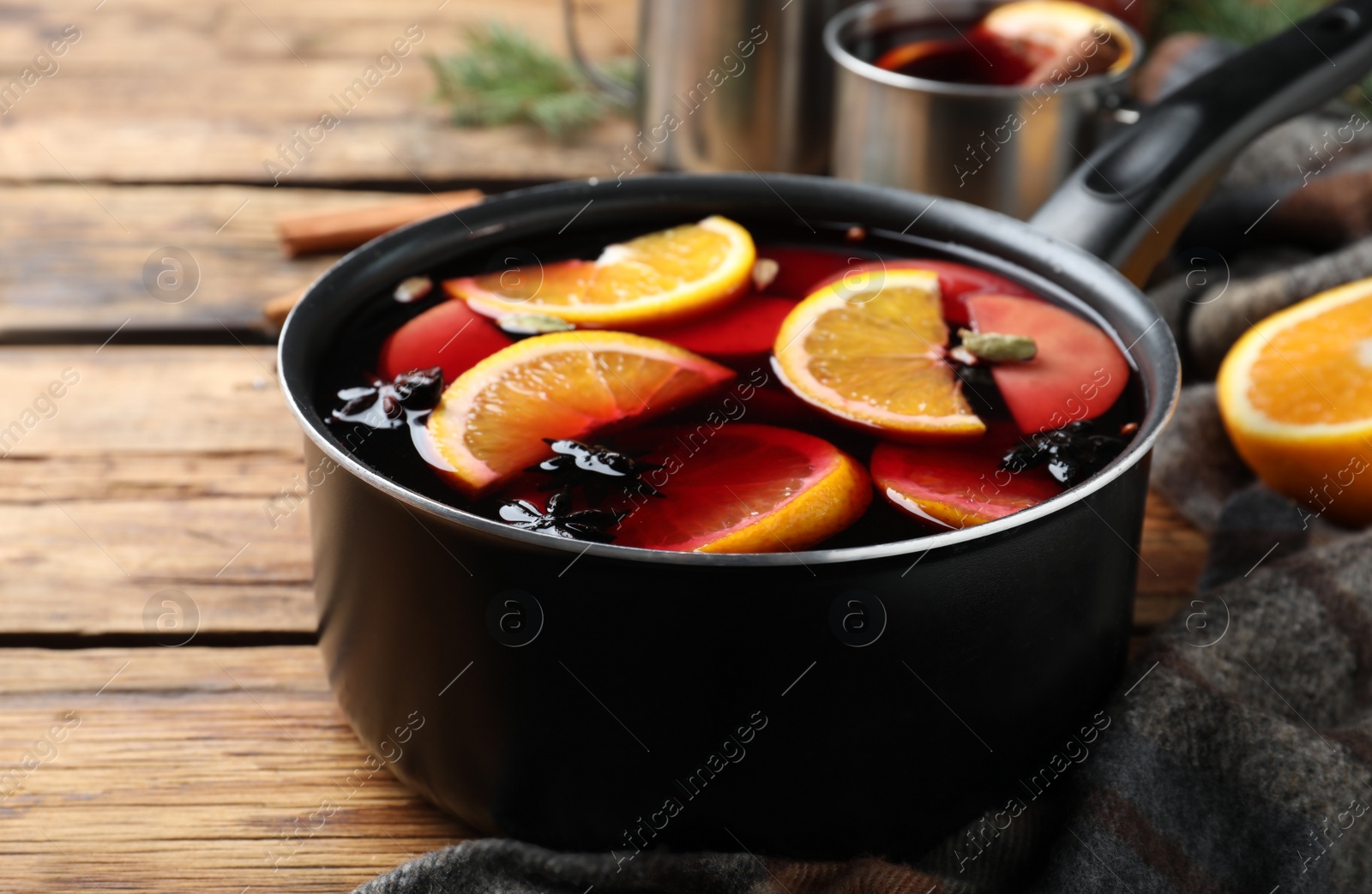 Photo of Delicious mulled wine on wooden table, closeup