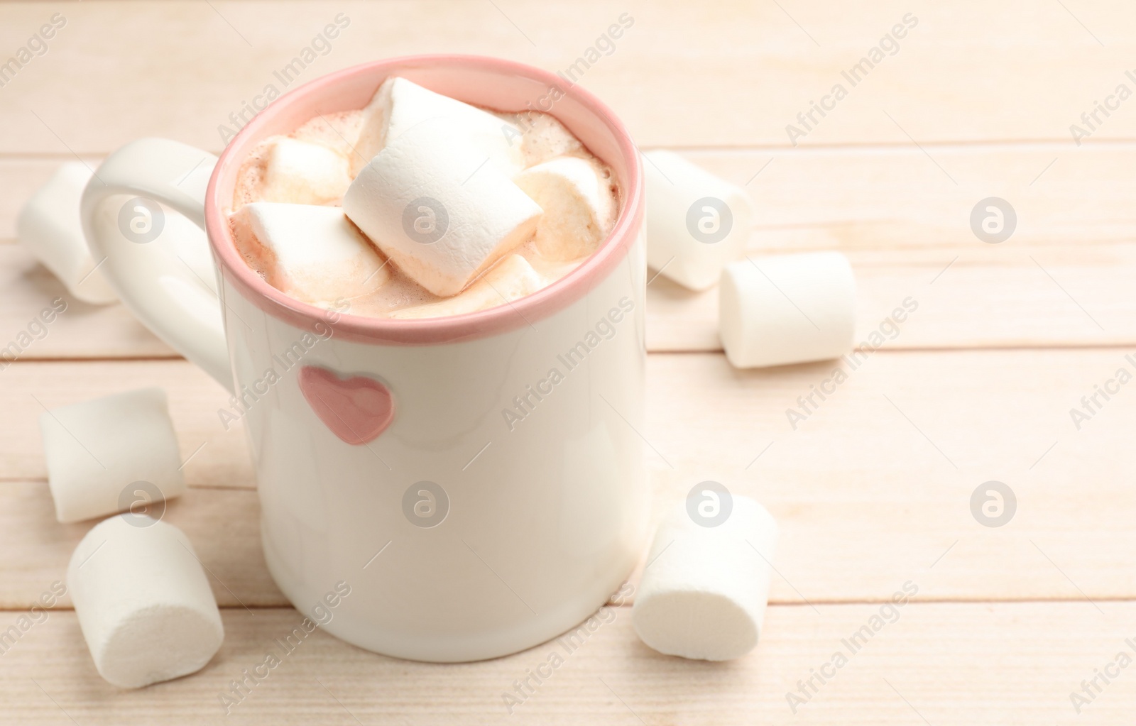 Photo of Tasty hot chocolate with marshmallows on light wooden table, closeup. Space for text